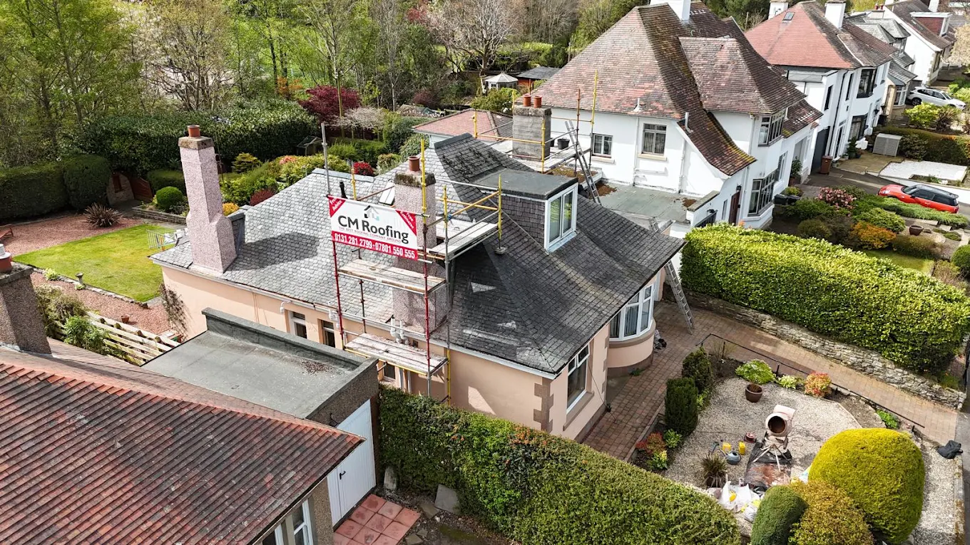 Drone view of a slate re-roof in progress with CM Roofing scaffolding
